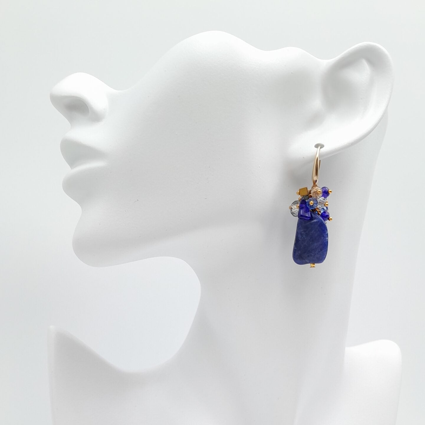 Blue pendant earrings on a white mannequin bust