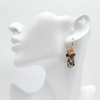 Earring on a white mannequin ear stand against a white background