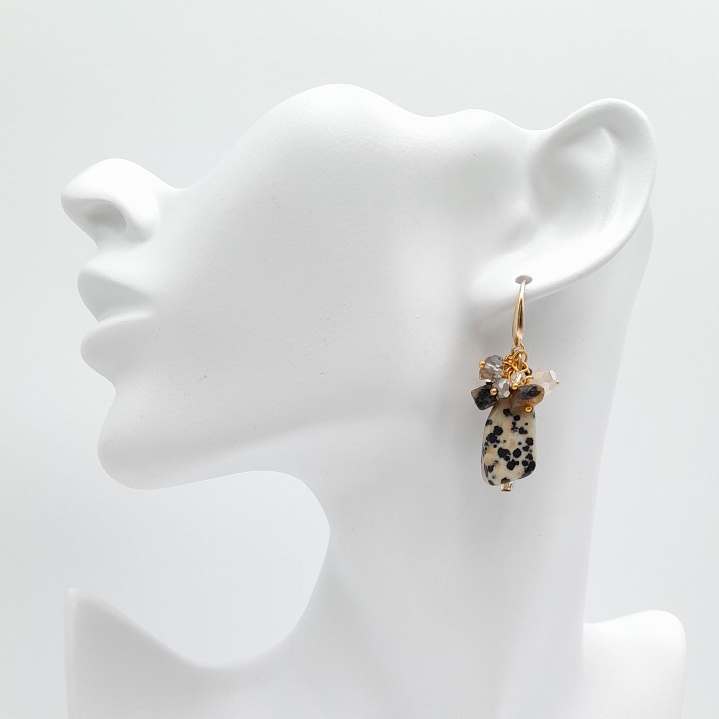 Earring on a white mannequin ear stand against a white background