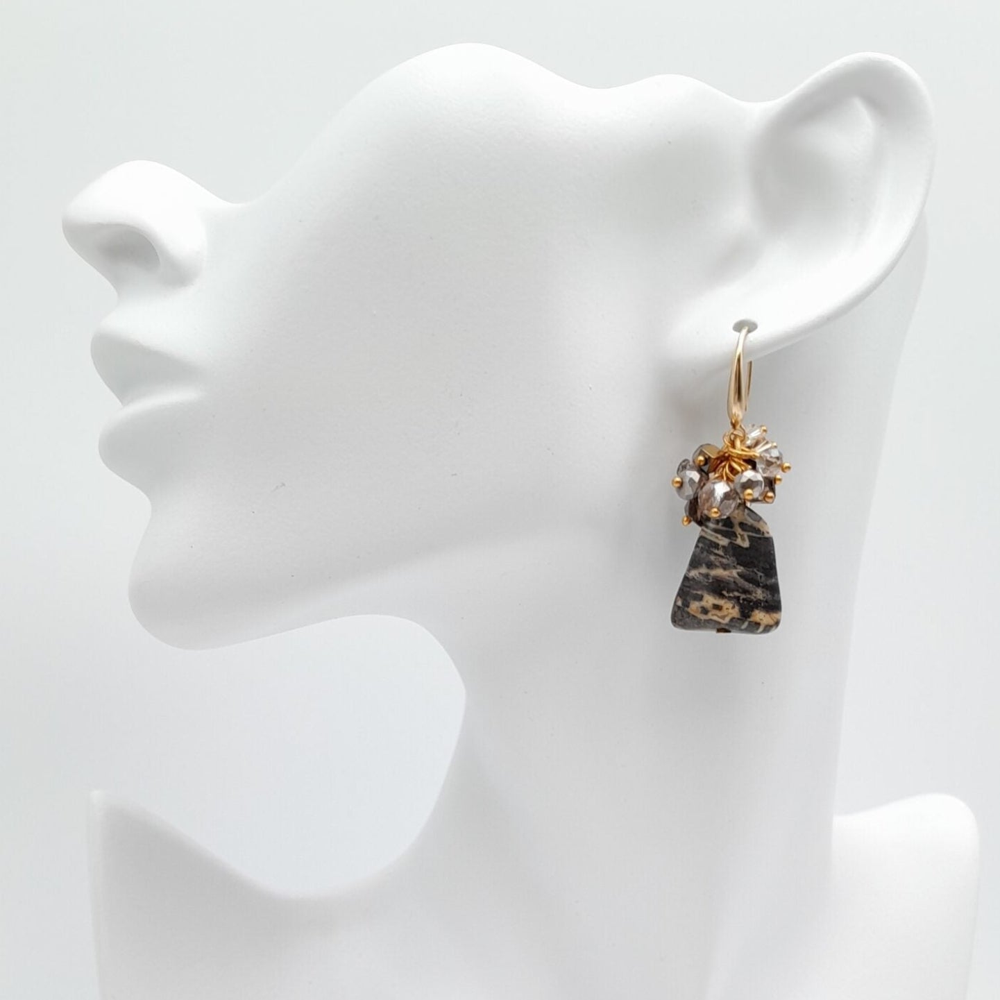 Earrings on a white mannequin bust with a plain background