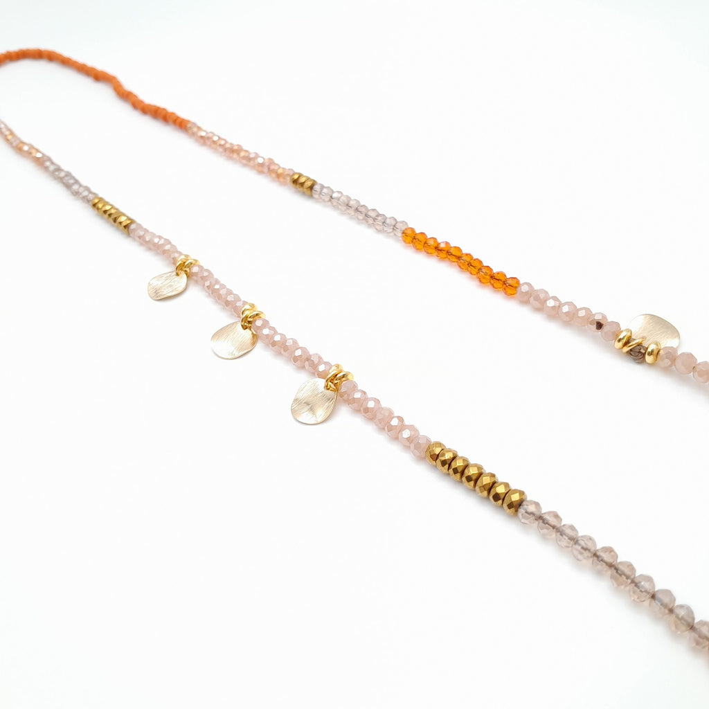 Beaded necklace with orange, pink, and gold beads on a white background
