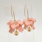 Pink floral earrings with gold accents on a white background
