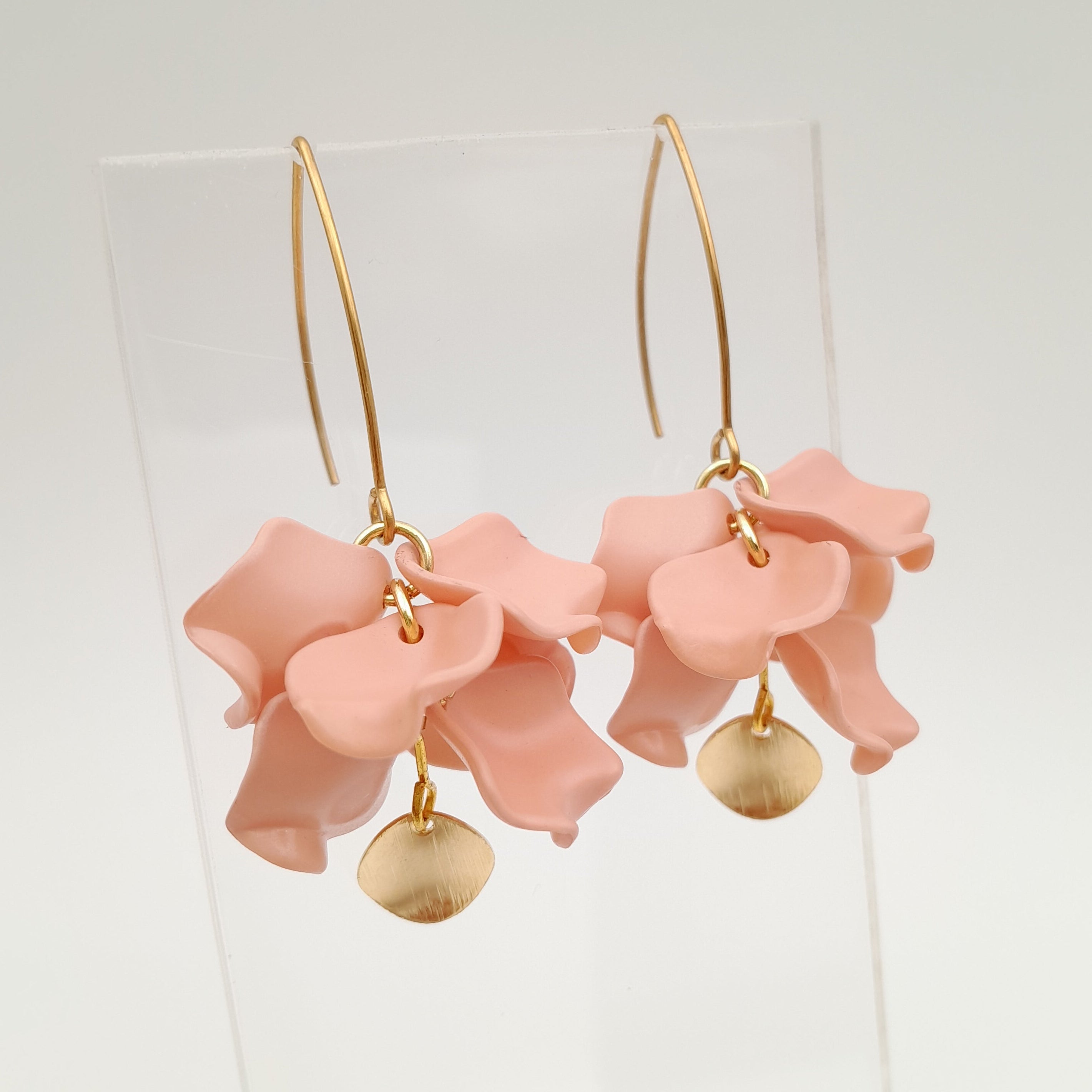 Pink floral earrings with gold accents on a white background